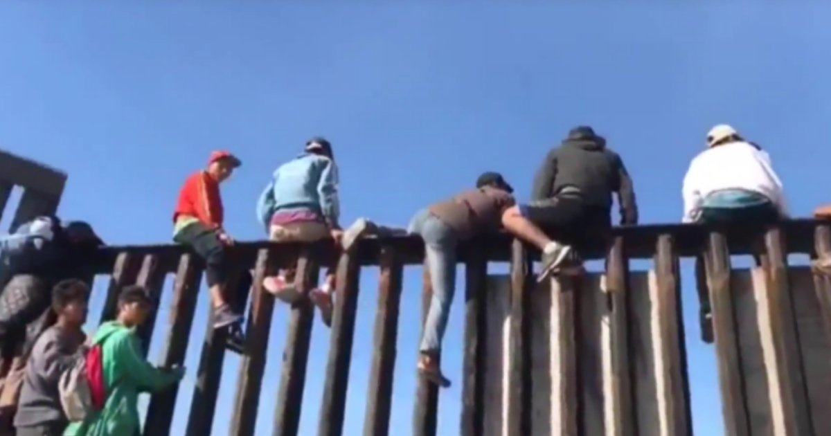 Caravan Hits US-Mexico Border, Members Immediately Start Climbing Fence