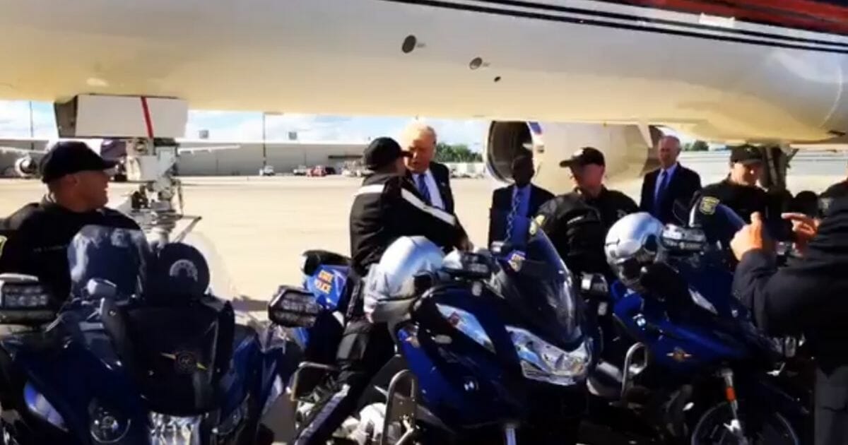 Donald Trump shakes hands with police officers outside his airplane on a Michigan stop during his 2016 presidential campaign.