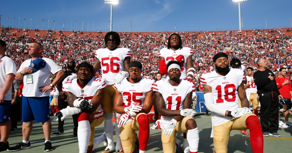 Eli Harold #57, Eric Reid #35, Marquise Goodwin #11 and Louis Murphy #18 of the San Francisco 49ers kneel during the anthem