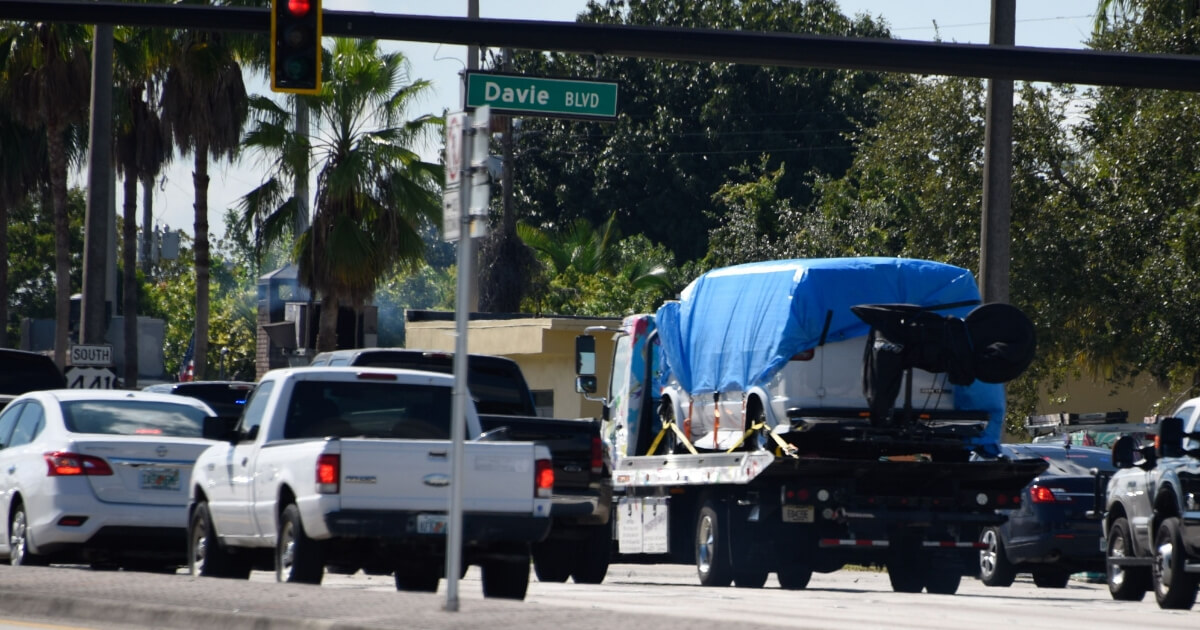 A van covered in blue tarp is towed by FBI investigators on Friday in Plantation, Florida, in connection with the 12 suspicious packages mailed to top Democrats.