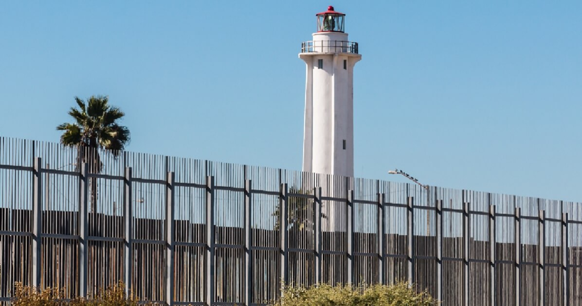 The norder fence separating San Diego, California, and Tijuana, Mexico, is pictured with El Faro de Tijuana lighthouse on the Mexico side.