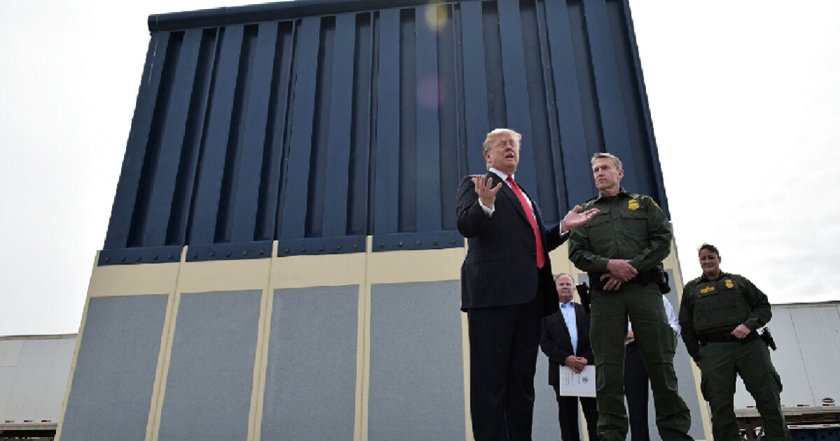 President Donald Trump with Border Patrol agents at a wall prototype.