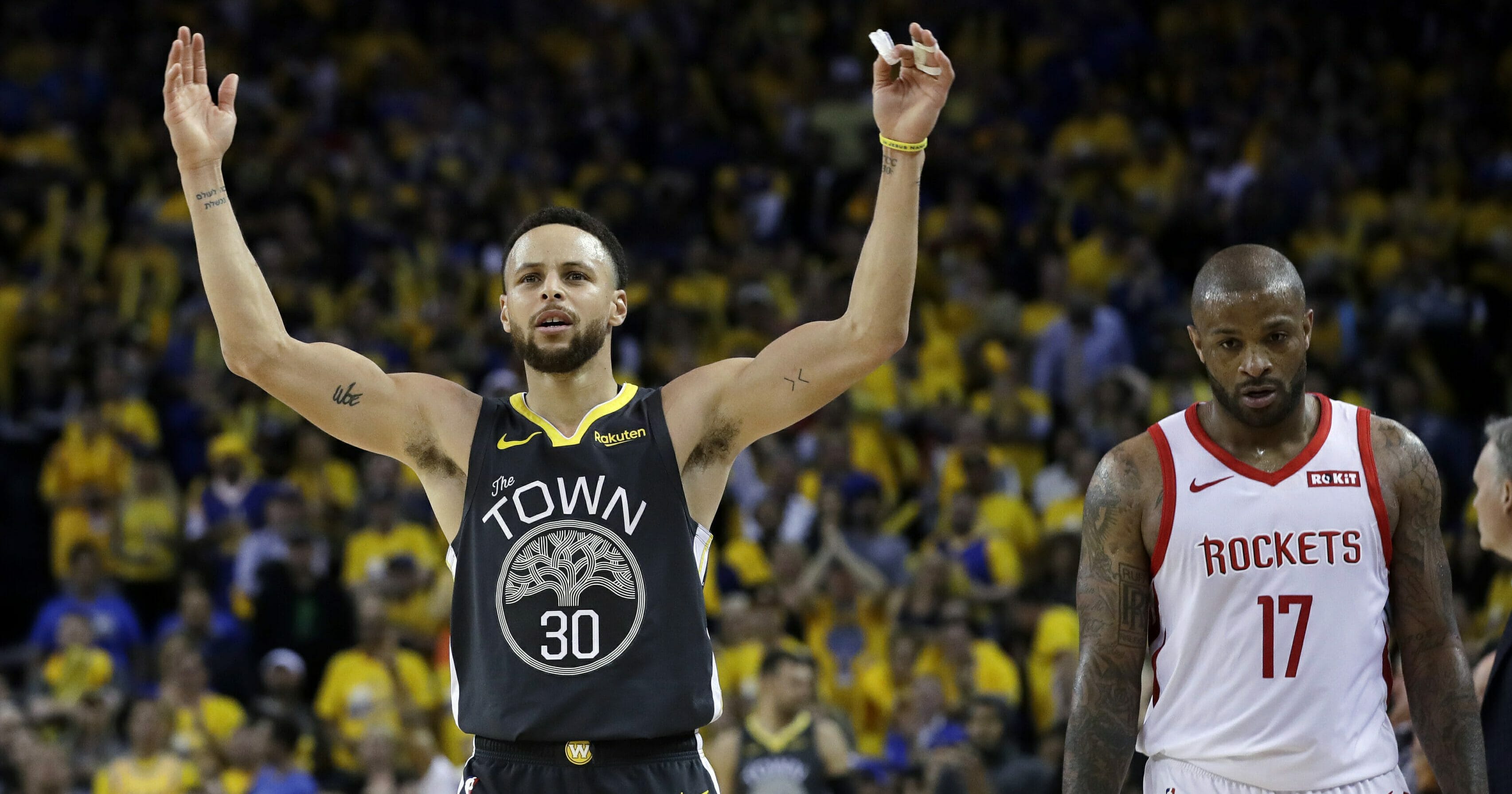 The Golden State Warriors' Stephen Curry, left, celebrates next to the Houston Rockets' P.J. Tucker.