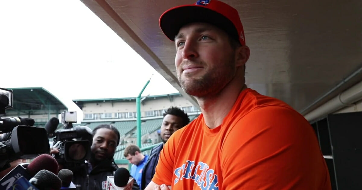 Syracuse Mets outfielder Tim Tebow talks to reporters.