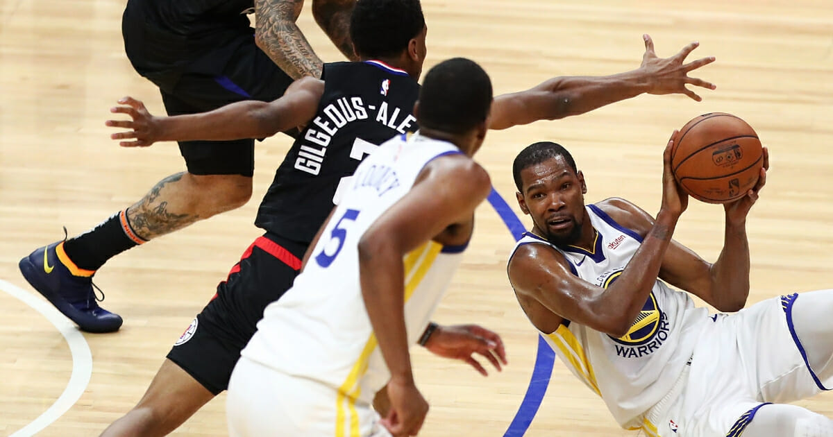 Kevin Durant of the Golden State Warriors looks for a pass against Shai Gilgeous-Alexander of the Los Angeles Clippers during the third quarter at Staples Center on April 18, 2019 in Los Angeles.