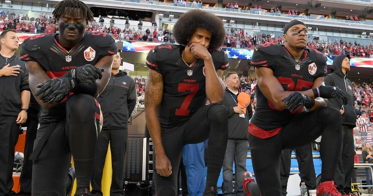 Members of the San Francisco 49ers kneel in protest during the national anthem prior to their NFL game against the Arizona Cardinals on October 6, 2016.