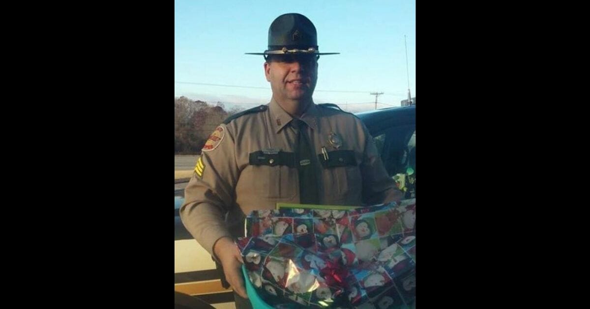 Officer Tidwell of the Tennessee Highway Patrol gives a woman Christmas gifts for her foster children.