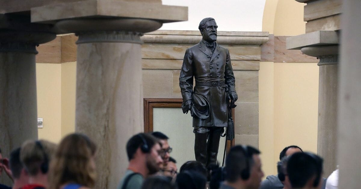 Tourists walk past the statue of Confederate General Robert E. Lee that is located inside the U.S. Capitol on Aug. 17, 2017, in Washington, D.C.