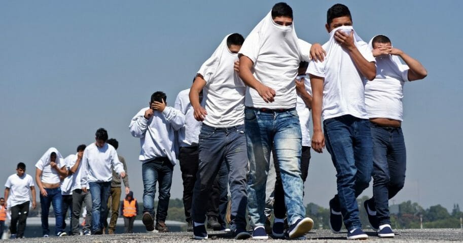 Guatemalan migrants deported from the United States cover their faces after their arrival in Guatemala City on Nov. 21, 2019.