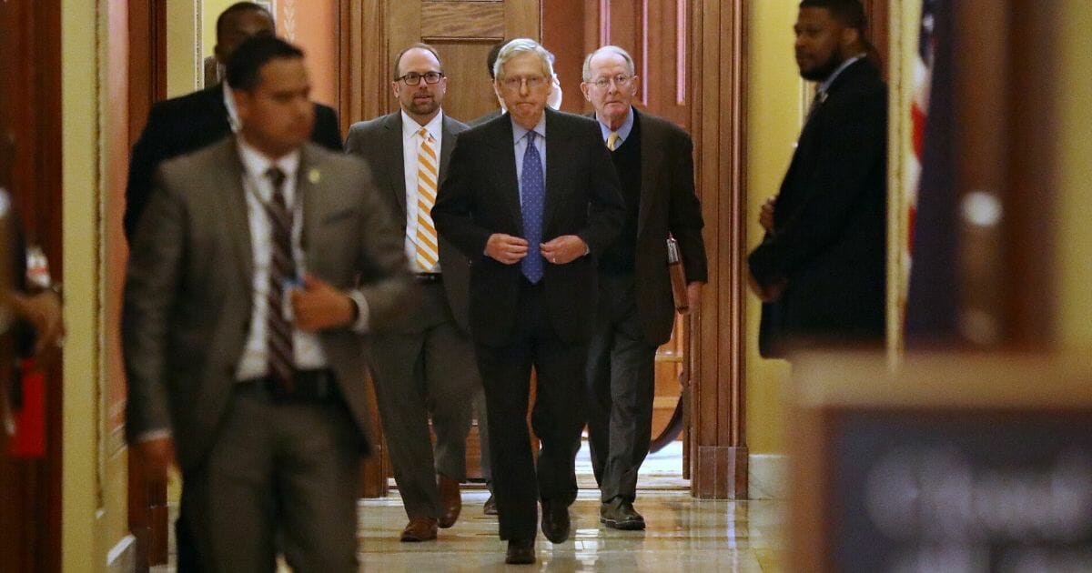 Senate Majority Leader Mitch McConnell of Kentucky, center, and Sen. Lamar Alexander of Tennessee, second from right, leave a meeting on the coronavirus relief package in the Capitol's Strom Thurmond Room on March 24, 2020.