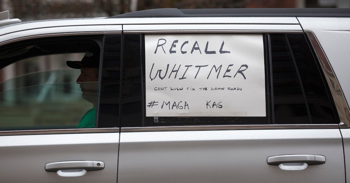 A man sits in his car while driving toward the Capitol