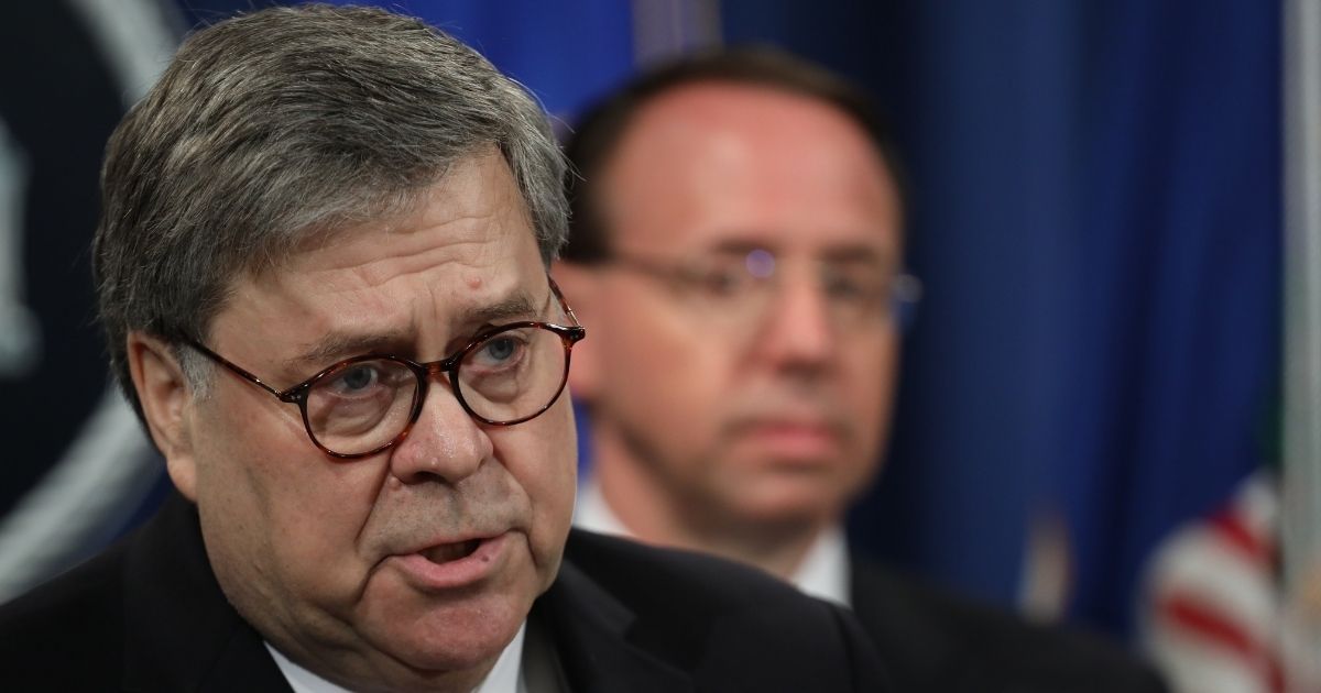 WASHINGTON, DC - APRIL 18: U.S. Attorney General William Barr speaks about the release of the redacted version of the Mueller report as U.S. Deputy Attorney General Rod Rosenstein listens at the Department of Justice April 18, 2019 in Washington, DC. Members of Congress are expected to receive copies of the report later this morning with the report being released publicly soon after.