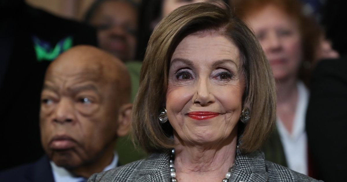 WASHINGTON, DC - DECEMBER 06: House Speaker Nancy Pelosi (D-CA) stands with Rep. John Lewis (D-GA) (L) and other members during a news conference before the House votes on the H.R. 4, The Voting Rights Advancement Act, on December 6, 2019 in Washington, DC. When the president signs the act into law H.R. 4 will restore the full strength of the voting rights act, after a 2013 Supreme Court decision gutted it unleashing widespread voter suppression.