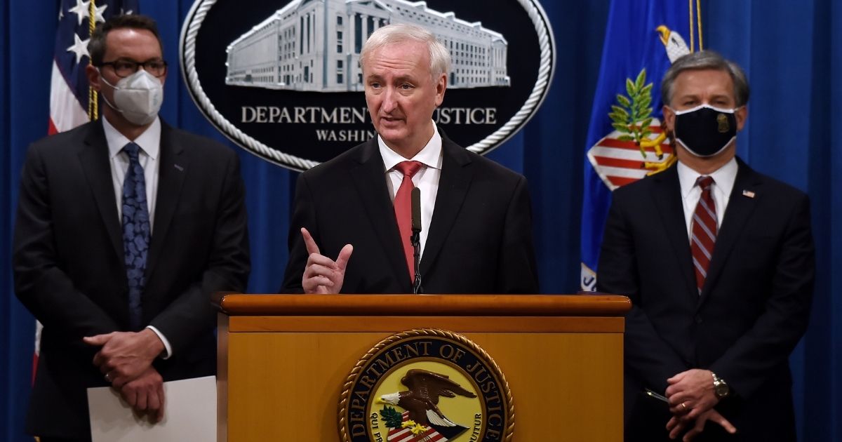 Deputy Attorney General Jeffrey A. Rosen speaks as FBI Director Christopher Wray, right, and Immigration and Customs Enforcement Deputy Director Derek Benner, left, look on at a news conference at the Justice Department on Sept. 22, 2020, in Washington, D.C. The officials reported that 179 people were arrested and more than $6.5 million was seized in a worldwide crackdown on opioid trafficking on the dark net.