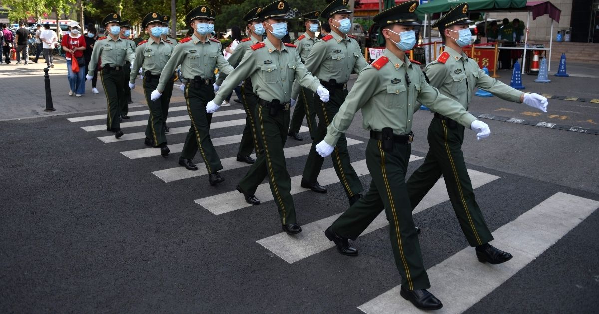 TOPSHOT - Paramilitary police officers patrol in a shopping area on the closing day of the Chinese People's Political Consultative Conference (CPPCC) in Beijing on May 27, 2020.