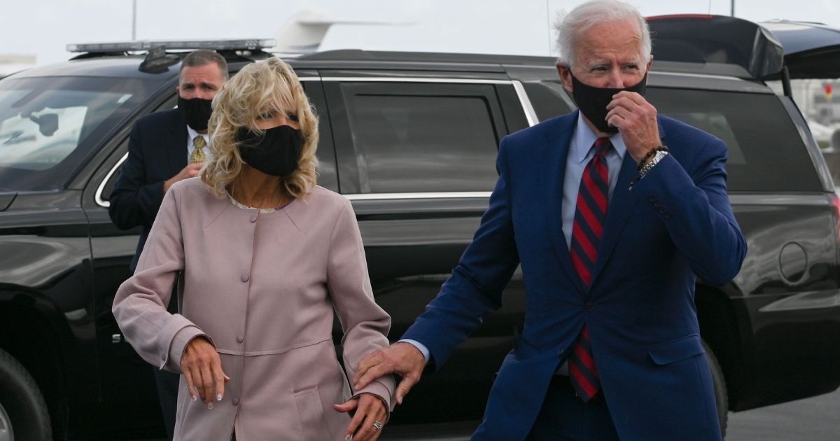 Democratic presidential nominee and former Vice President Joe Biden and his wife Jill walk on the tarmac after landing at the Miami International Airport in Miami, Florida as he begins a one-day campaign trip in Florida on October 5, 2020.