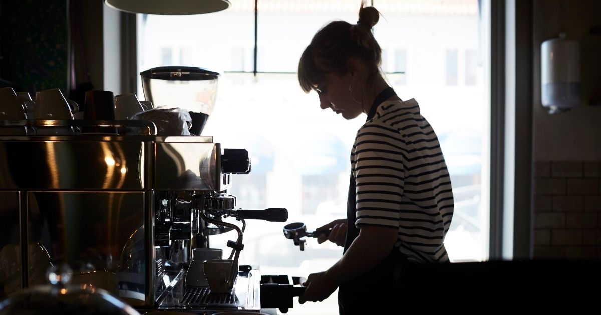 This stock photo portrays a lone barista manning a coffee shop counter. One coffee shop in Arizona is being praised for raising the minimum wage for their employees, though many other small businesses will likely be unable to follow suit.