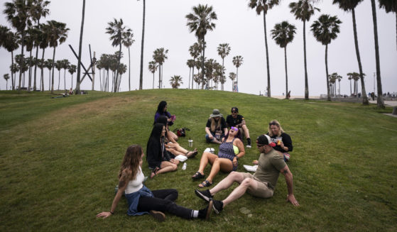 A group of friends mingle on the beach in Los Angeles on May 5, 2021.