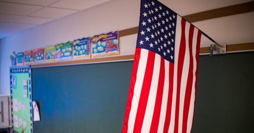 An American flag is pictured in a classroom in the stock image above.