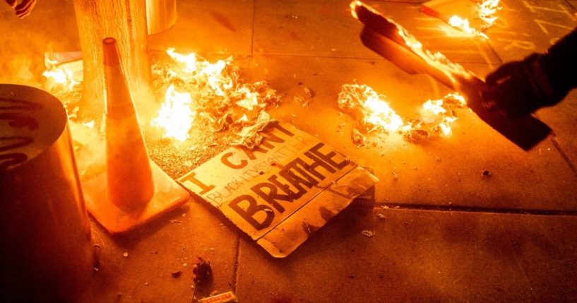 A Black Lives Matter protester burns a sign outside the Mark O. Hatfield United States Courthouse on July 21, 2020, in Portland, Oregon.