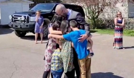 Pastor Tim Stephens of Fairview Baptist Church in Calgary, Alberta, Canada, hugs his family before being arrested on Sunday.