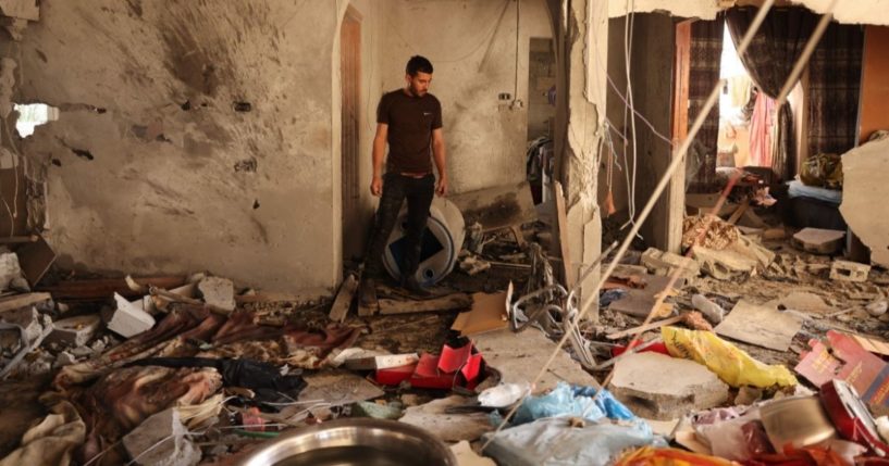 A relative inspects the damage inside a house in Deir el-Balah in the central Gaza Strip, on Wednesday, following an Israeli air strike.