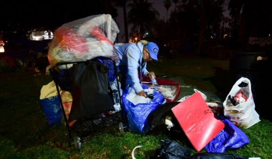 A homeless woman packs her belongings ahead of an expected clearing out of the homeless encampment at Echo Park Lake in Los Angeles, on March 24, 2021.