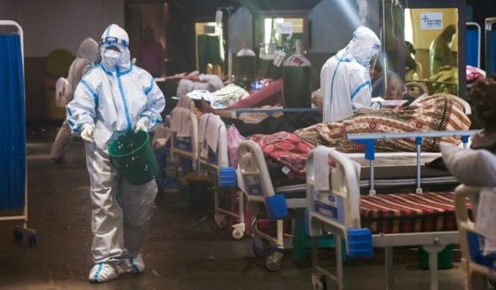 Health workers wearing a personal protective equipment suits attend to patients inside a banquet hall temporarily converted into a COVID-19 ward in New Delhi on May 1.