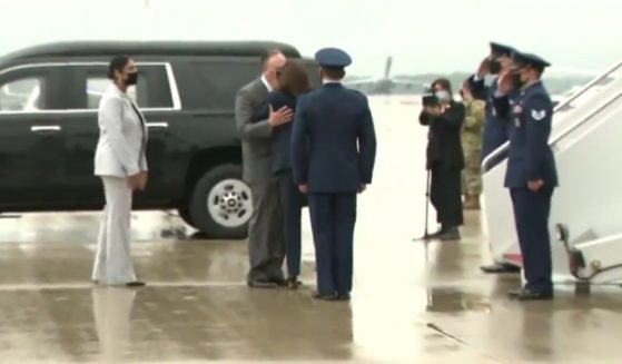 Vice President Kamala Harris and second gentleman Doug Emhoff share a kiss, both wearing masks.