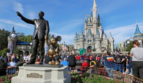 Visitors watch a show near a statue of Walt Disney and Micky Mouse at Walt Disney World's Magic Kingdom in Lake Buena Vista, Florida, on Jan. 9, 2019.