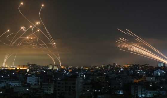 The Israeli Iron Dome missile defense system, left, intercepts rockets, right, fired by Hamas toward southern Israel from Beit Lahia in the northern Gaza Strip as seen in the sky above the Gaza Strip overnight on Friday.