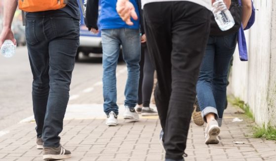 Crowd scene of whites walking on a sidewalk.