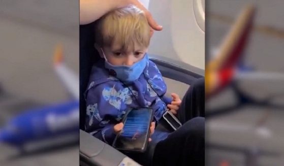 Orion Scott, 3, wears a face mask aboard his family's plane.