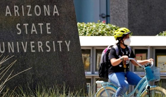 A cyclist crosses an intersection on the campus of Arizona State University on Sept. 1, 2020, in Tempe, Arizona.