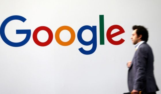 A man passes by the logo of Google on May 16, 2019, in Paris.