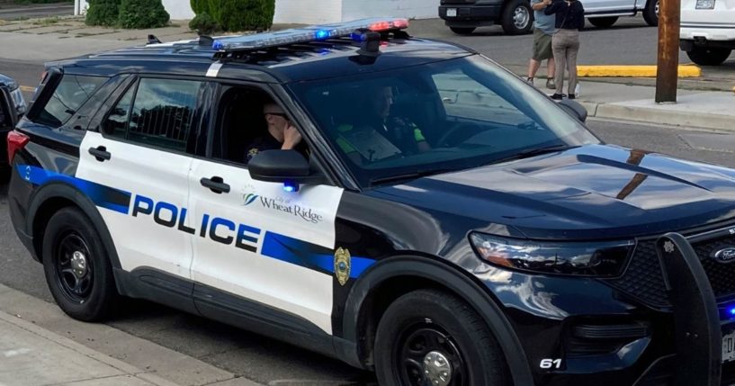 Police cars line up for a procession in honor of an officer who was fatally shot in Arvada, Colorado, on Monday.