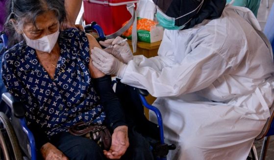 An elderly woman receives the Sinovac coronavirus vaccine at a sports facility in Banda Aceh, Indonesia, on Wednesday.