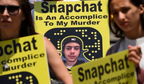 Family and friends of people who died after being poisoned by pills containing fentanyl carry signs as they protest near the Snap, Inc. headquarters, makers of the Snapchat social media application, on June 4 in Santa Monica, California.