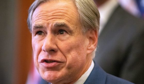 Republican Texas Gov. Greg Abbott signs Senate Bills 2 and 3 during a news conference at the Capitol on June 8, 2021, in Austin, Texas.