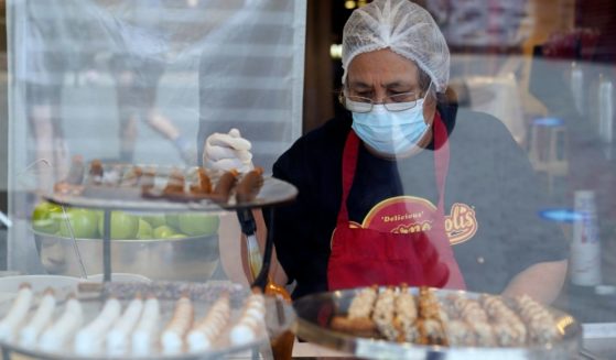 A worker wears a mask while preparing desserts at the Universal City Walk, in Universal City, California, on May 14, 2021.