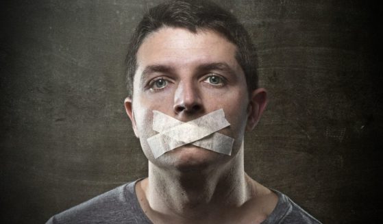 A man with tape in an "X" shape over his mouth.