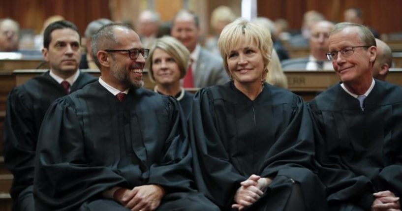 In this Jan. 14, 2020 file photo, Iowa Supreme Court Justices Christopher McDonald, left, Susan Christensen, center, and Edward Mansfield, right, attend Iowa Gov. Kim Reynolds' Condition of the State address at the Statehouse in Des Moines, Iowa.