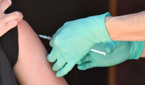 A medical assistant inserts into the arm the needle of a syringe containing the Johnson & Johnson COVID-19 vaccine at the Revolte Bar pub in Berlins Friedrichshain district in Germany on May 30.