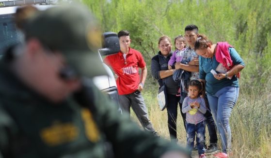 Central American asylum seekers wait as U.S. Border Patrol agents take groups of them into custody on June 12, 2018, near McAllen, Texas.