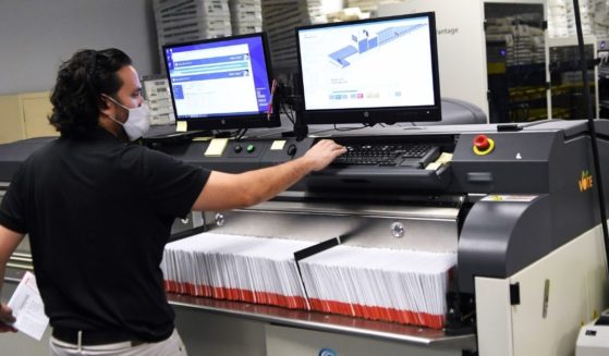 Bruno Morini loads mail-in ballots into a sorting machine at the Orange County Supervisor of Elections office in Orlando, Florida, on Oct. 26.