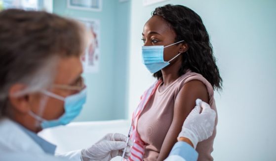 The above stock photo shows a woman getting vaccinated.