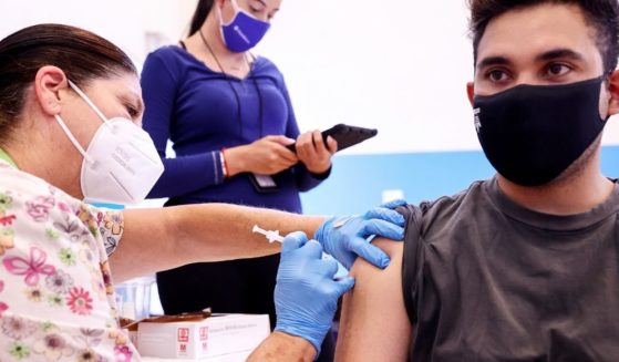 A nurse administers a dose of the Pfizer COVID-19 vaccine to a man on Thursday in Wilmington, California.