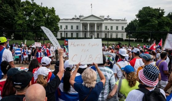 Protesters hold up signs during a demonstration in front of the White House on Sunday in Washington D.C.