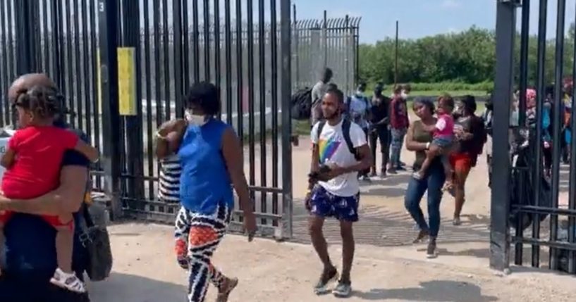 Illegal immigrants walk through a border gate into Del Rio, Texas.