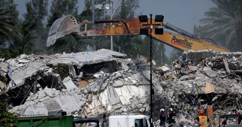 Excavators dig through the remains from the collapsed 12-story Champlain Towers South condo building on Friday in Surfside, Florida.